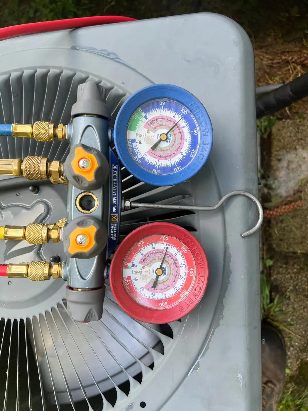 Manifold gauge set resting on top of an outdoor condenser
