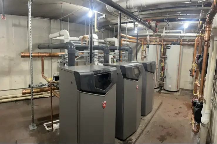 Commercial boiler room with three floor-standing boilers, venting and copper piping
