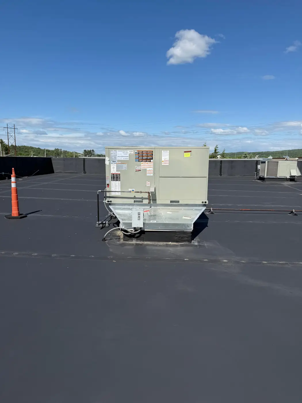Commercial rooftop unit on a flat roof under a blue sky