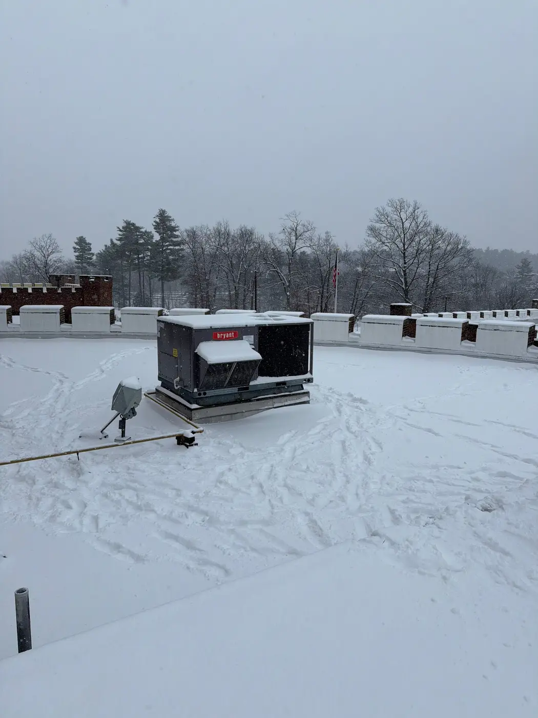 Commercial rooftop unit on a snow-covered flat roof