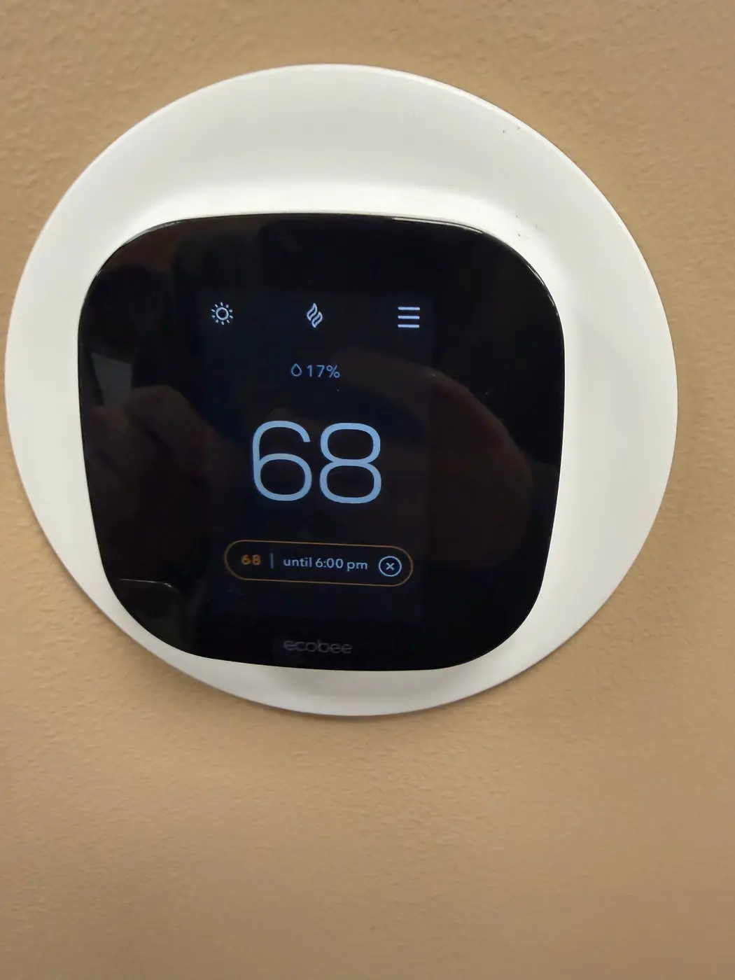 Smart thermostat on a wall showing 68 degrees